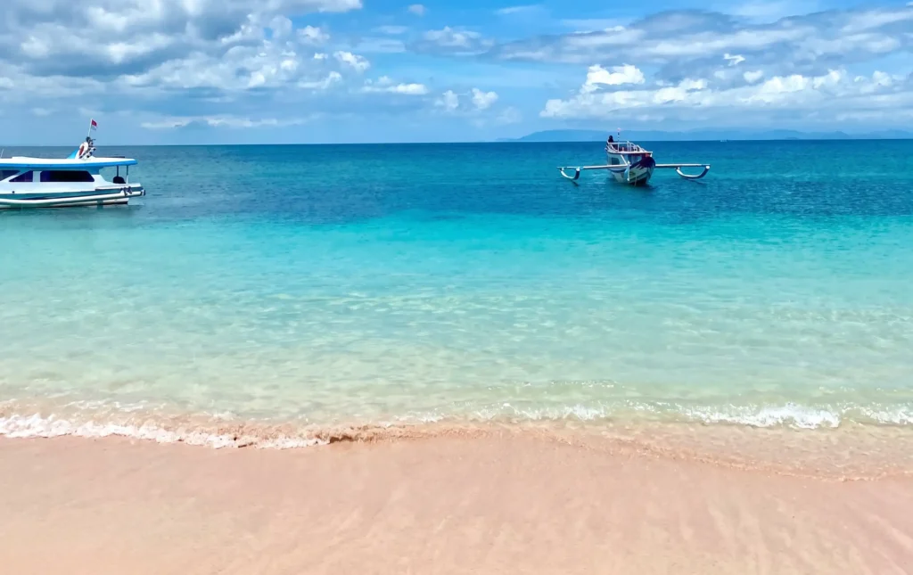 pink beach boats turquoise water