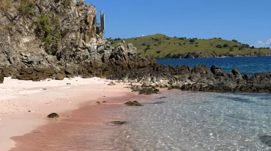 pink sand beach rocky cliffs